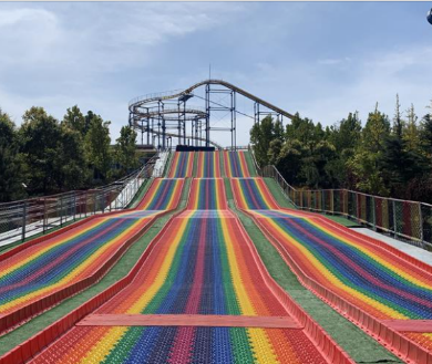 How does the lubrication of a rainbow slide compare to real snow?